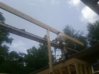 Carpenter setting a ridge beam over a new addition frame — Ice Dam Removal by Roofing Brothers in Fredericktown
