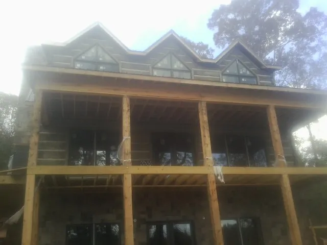 Dormers and porch framing on a large log home under construction — Roof Coating work by our crew in Fredericktown
