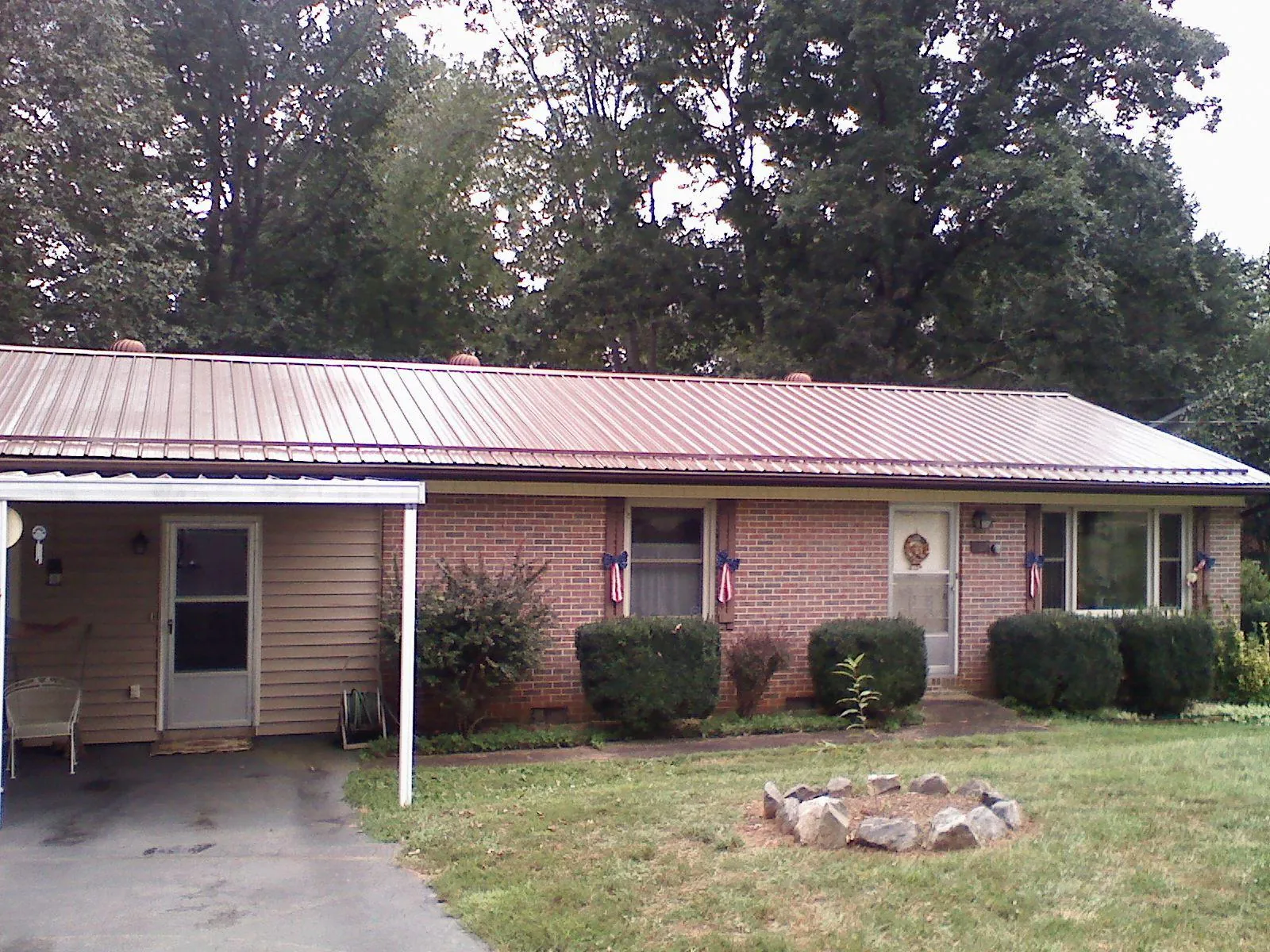Bronze metal roof and carport on a brick ranch home — Roof Repair work by our crew in Fredericktown